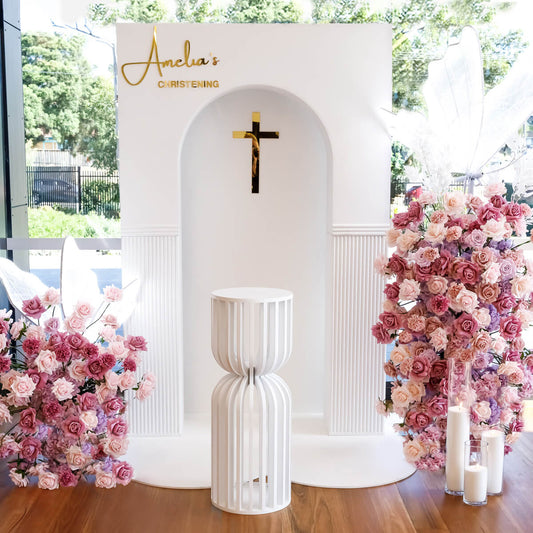 white 3d rectangle arch backdrop with flower arrangements and white plinth