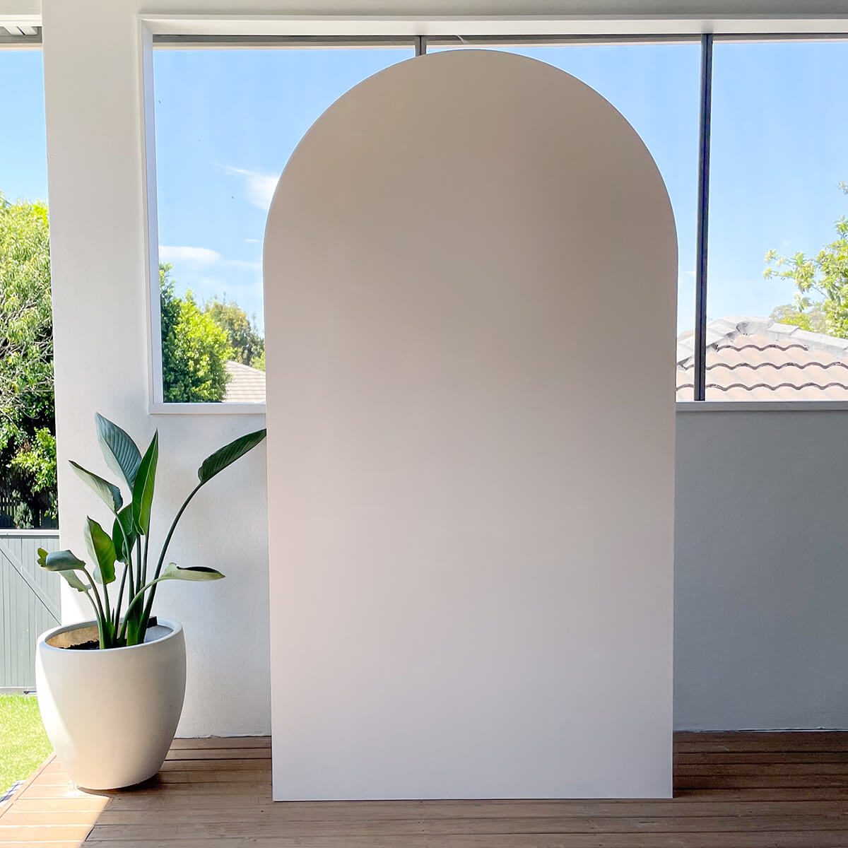 beige arch backdrop board standing on timber floor