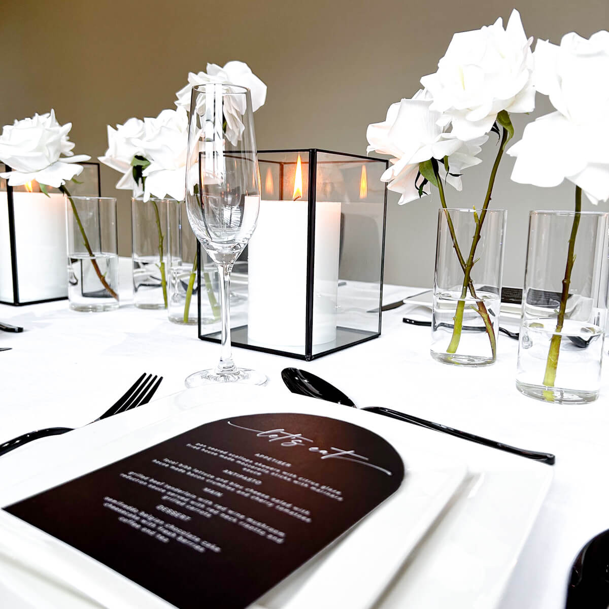 black and white table styling with menu cards flowers and candles