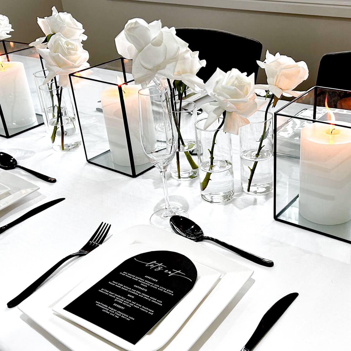 black and white table styling with menu cards flowers and cutlery