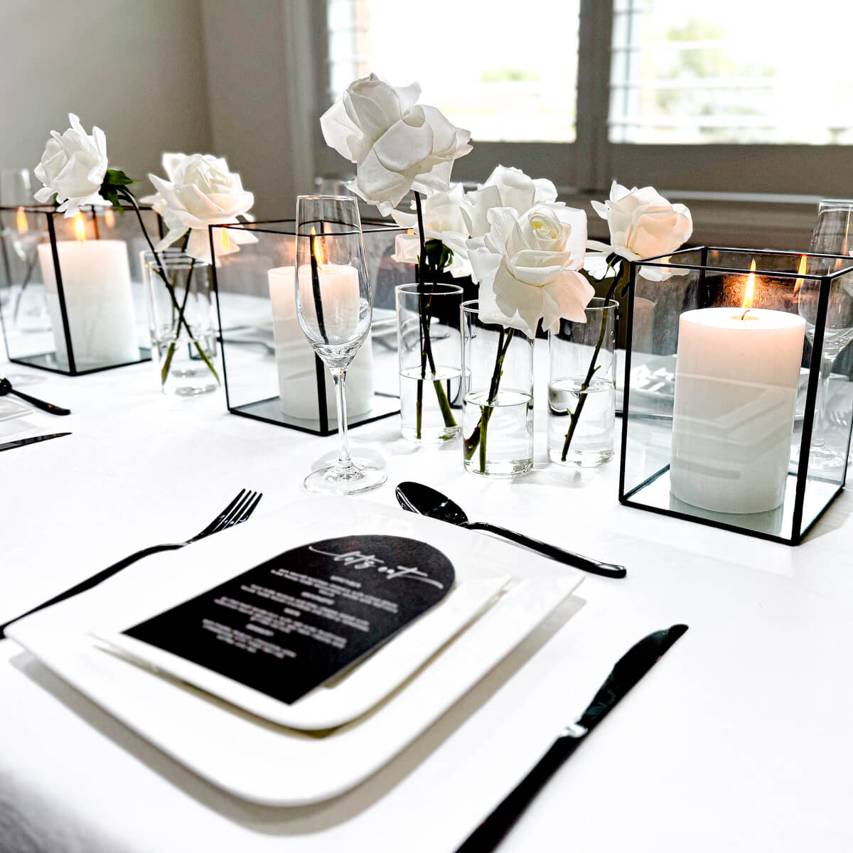 minimalistic table styling with white roses and black cutlery