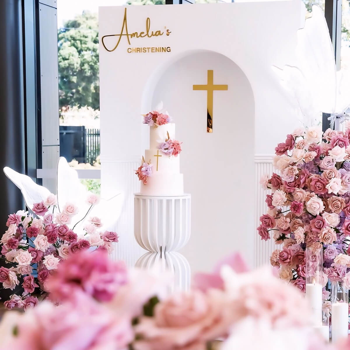 mixed pink and lilac flower arrangements around white 3d arch backdrop