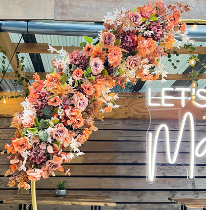 artificial flower arrangement hanging on gold circle hoop backdrop