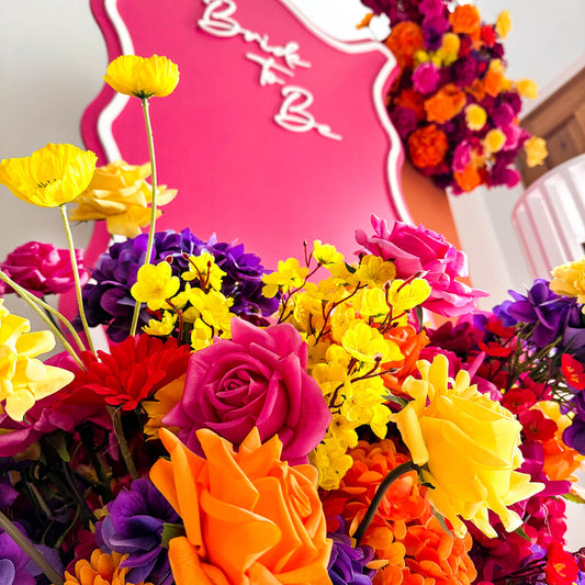 tropical coloured flower arrangements on hot pink and orange backdrops