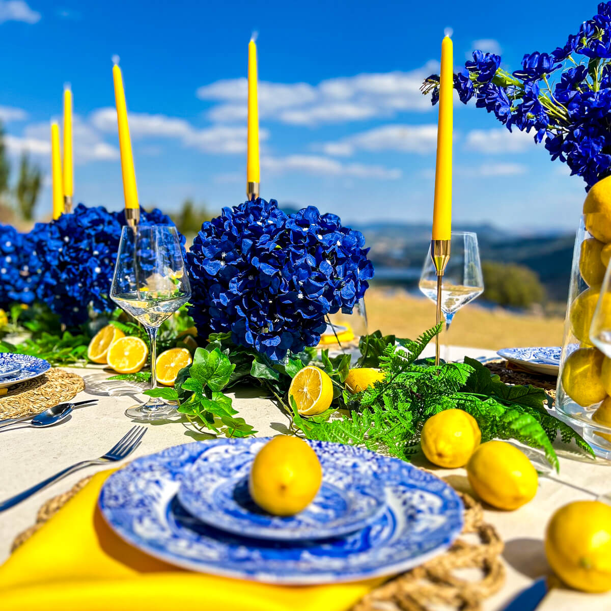 blue and yellow positano themed table display with lemons, flowers and candles