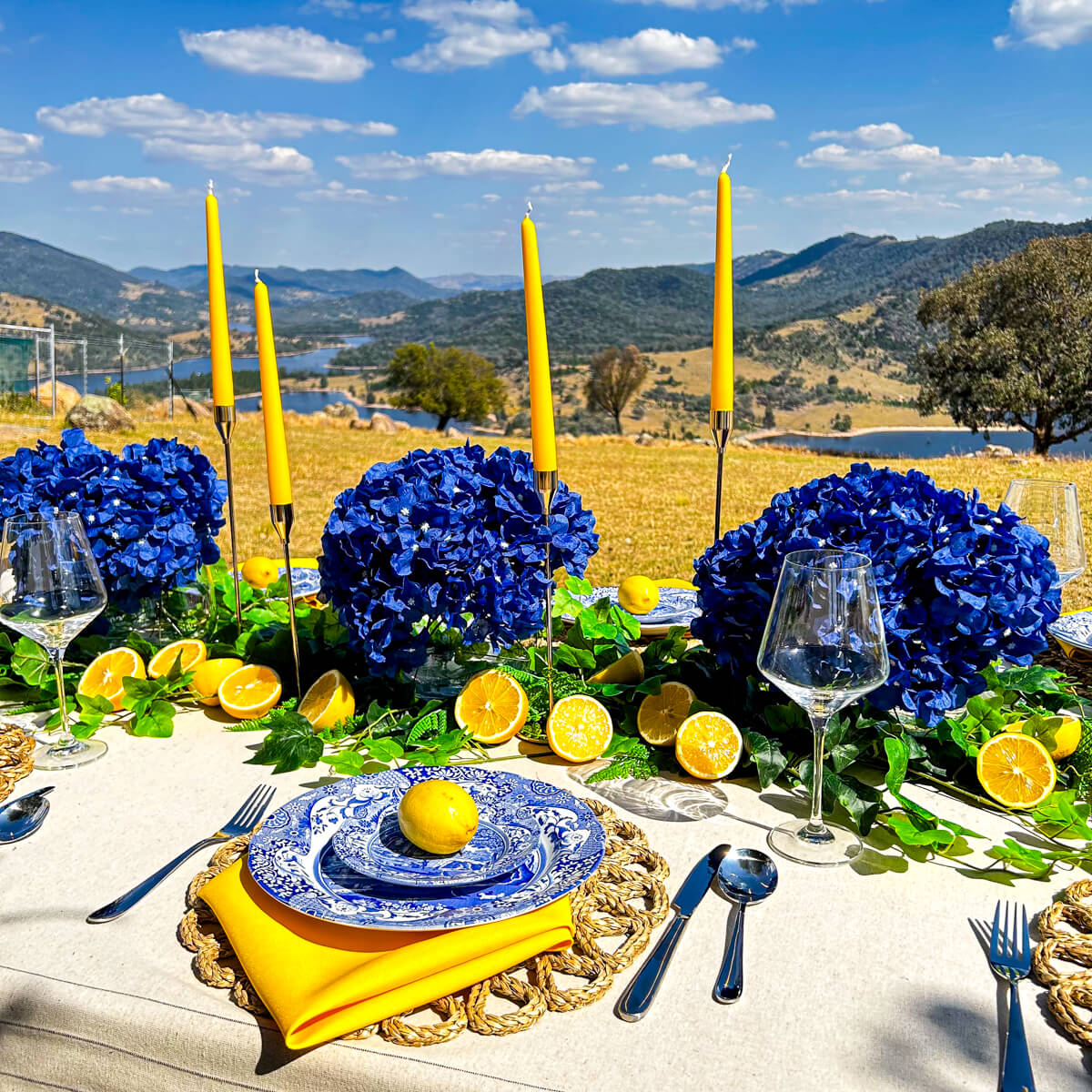 amalfi coast table setting with blue and yellow accents and mountain background