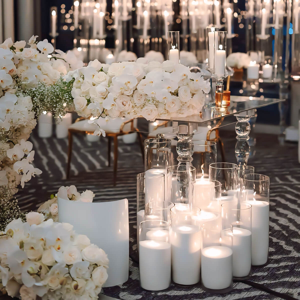 group of white sand candles on floor at wedding with flower arrangements