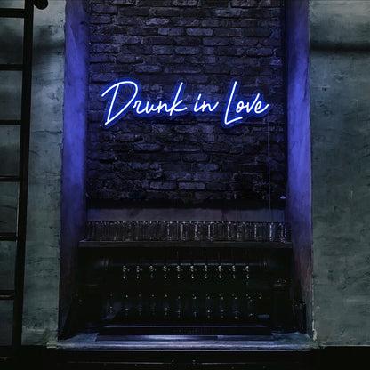 blue drunk in love neon sign hanging on bar wall