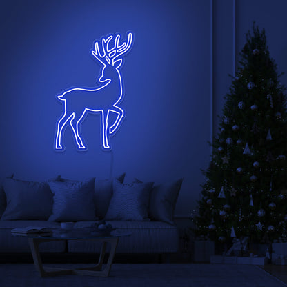 blue reindeer neon sign hanging on living room wall next to christmas tree