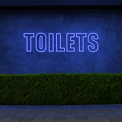 blue toilets neon sign hanging on outdoor wall