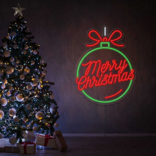 green and red Christmas ball neon sign hanging on wall next to Christmas tree