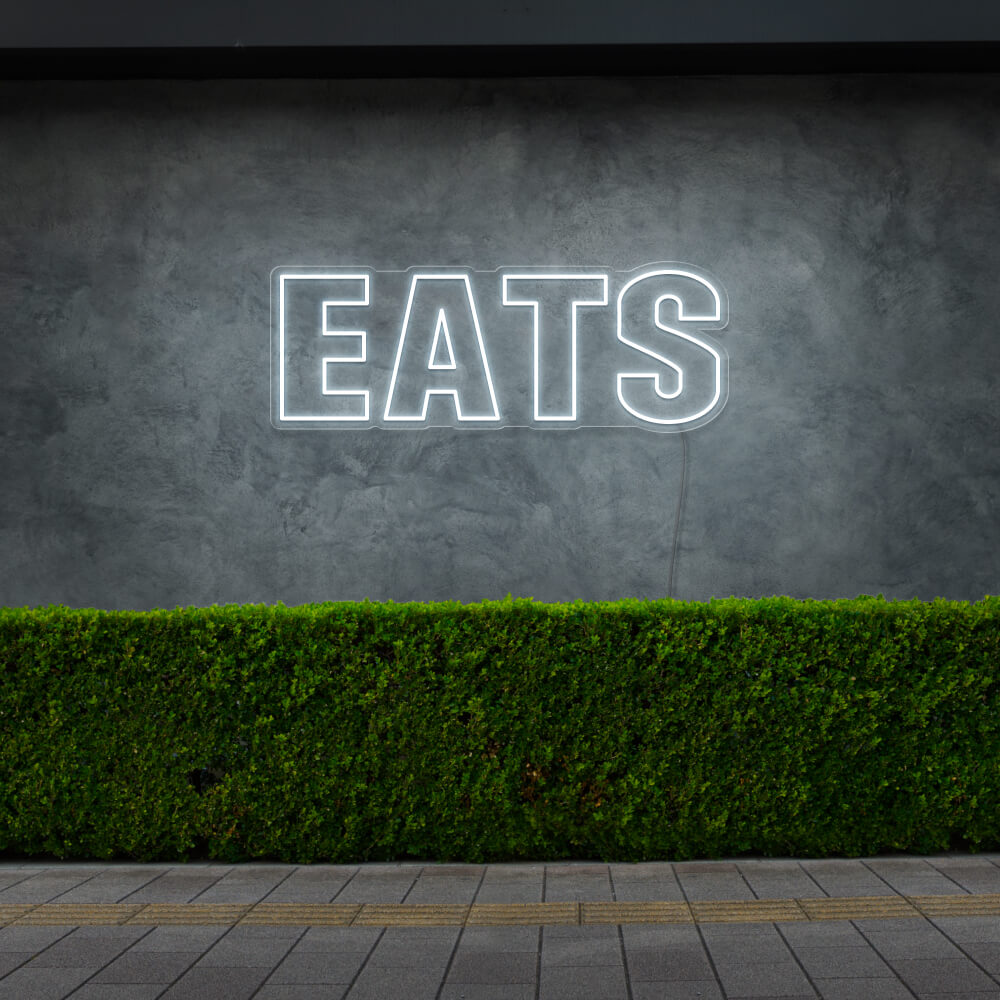 cold white eats neon sign hanging on outside wall