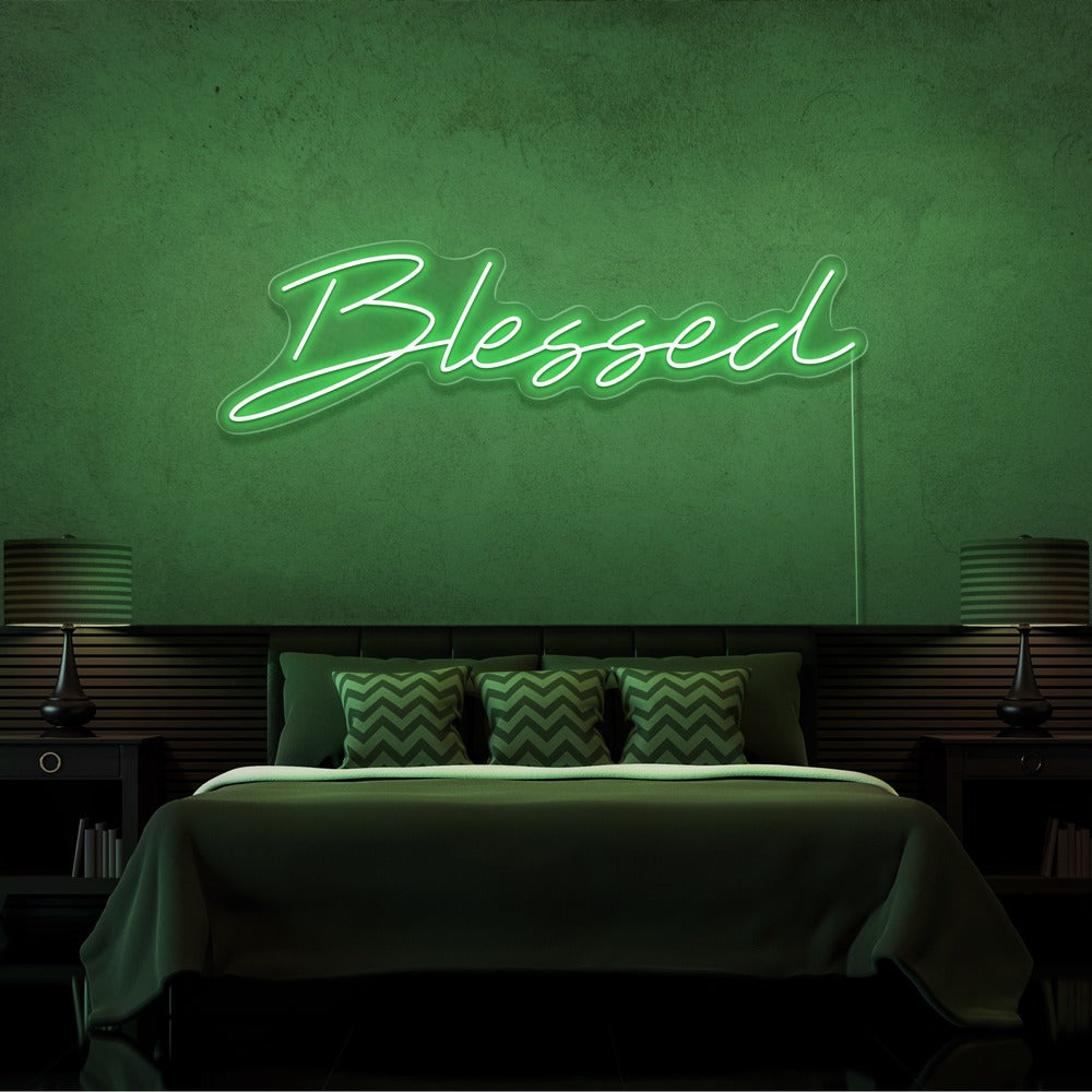 green blessed neon sign hanging on bedroom wall