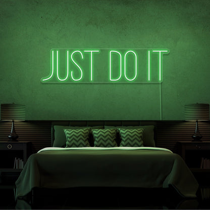 green just do it neon sign hanging on bedroom wall