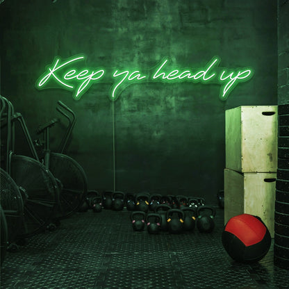 green keep ya head up neon sign hanging on gym wall