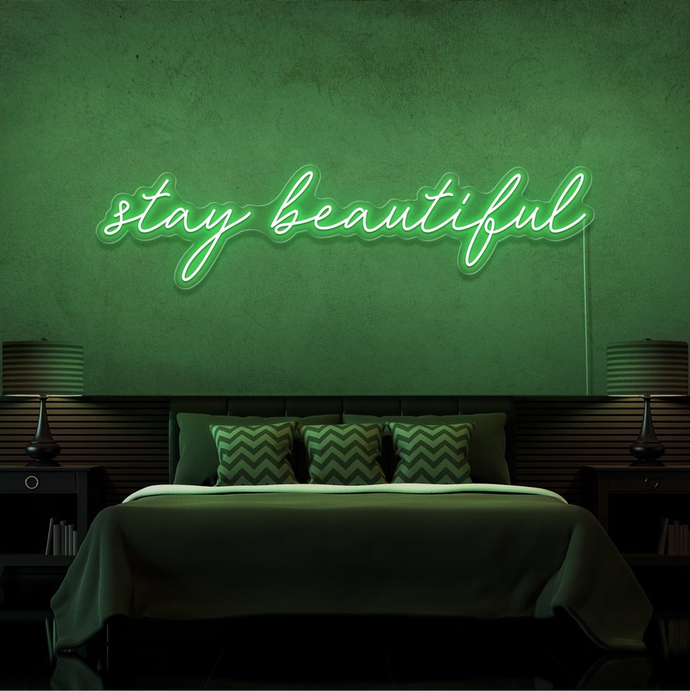 green stay beautiful neon sign hanging on bedroom wall