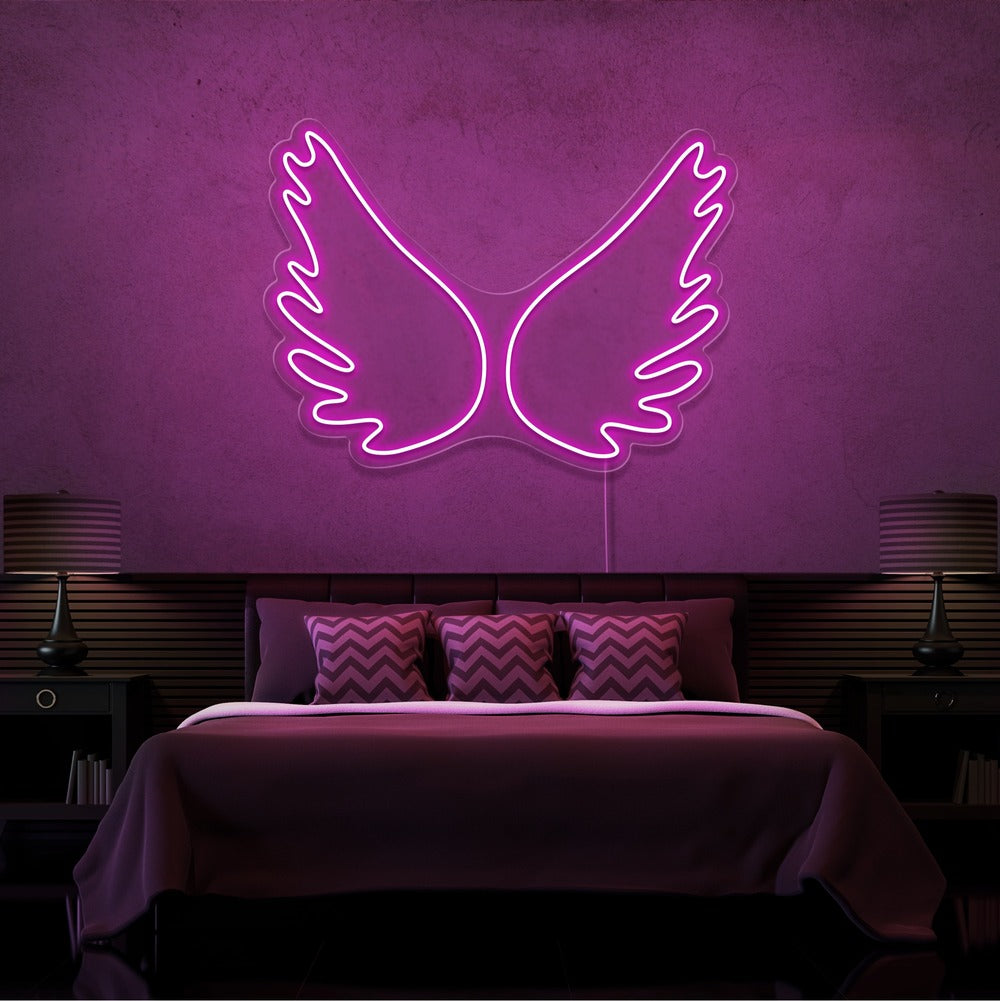 hot pink angel wings neon sign hanging on bedroom wall