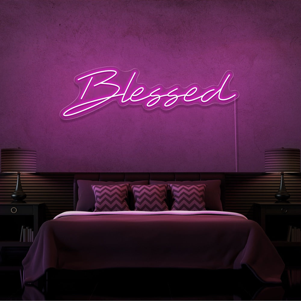 hot pink blessed neon sign hanging on bedroom wall