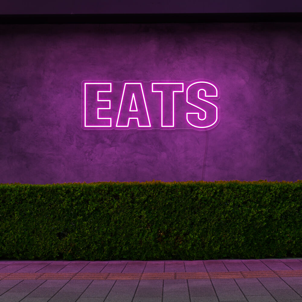 hot pink eats neon sign hanging on outside wall