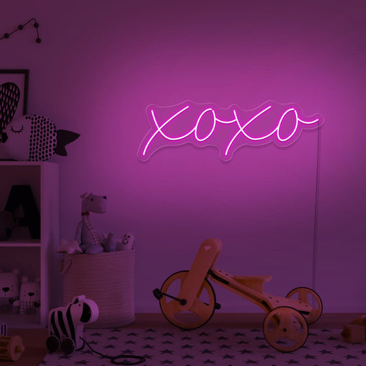 hot pink xoxo neon sign hanging on kids bedroom wall