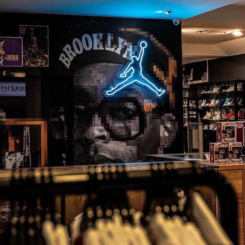 ice blue jordan jumpman neon sign hanging on wall in basketball shop