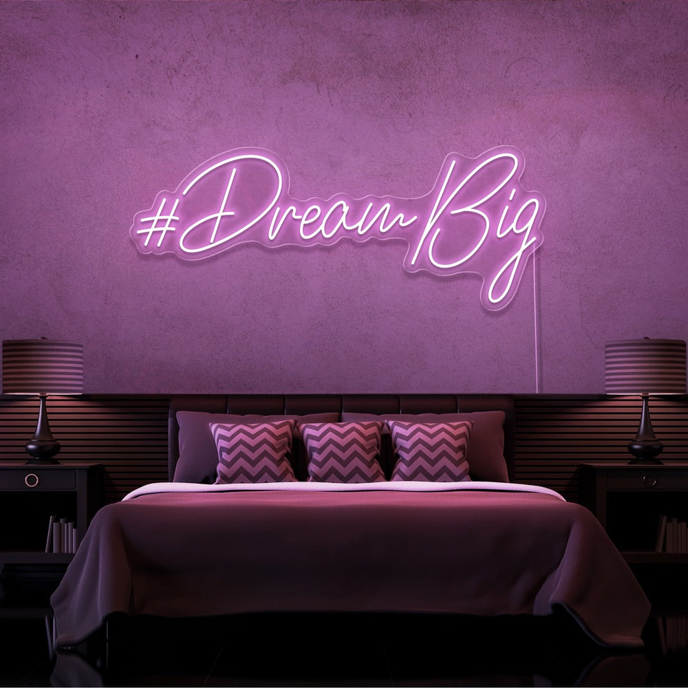 light pink dream big neon sign hanging on bedroom wall