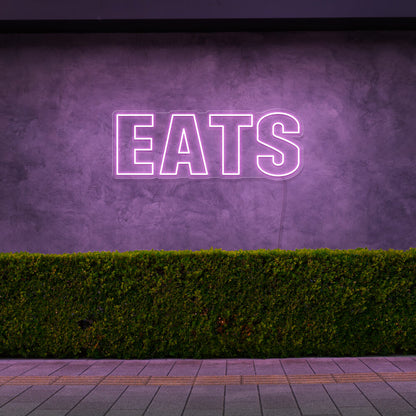 light pink eats neon sign hanging on outside wall