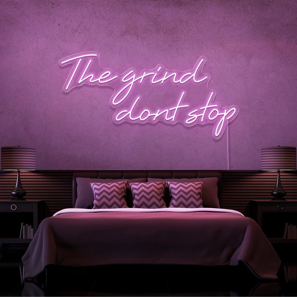 light pink the grind dont stop neon sign hanging on bedroom wall