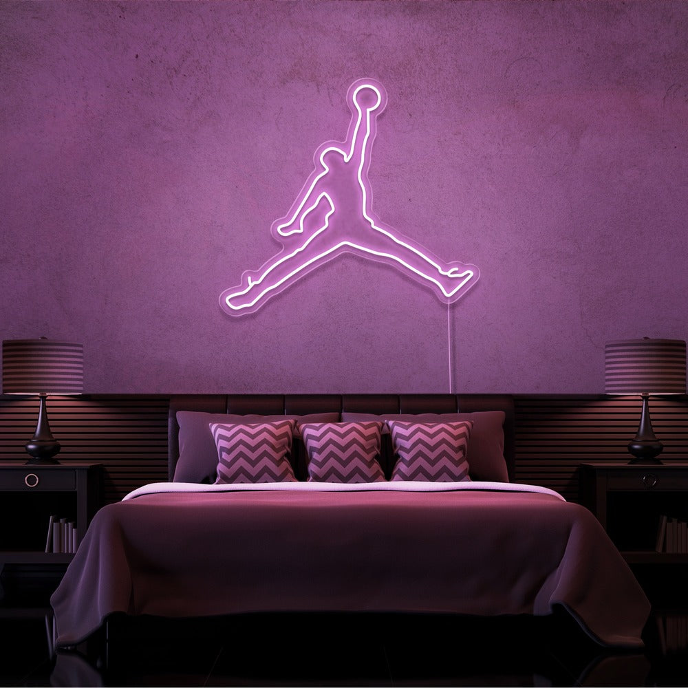 light pink jordan jumpman neon sign hanging on bedroom wall