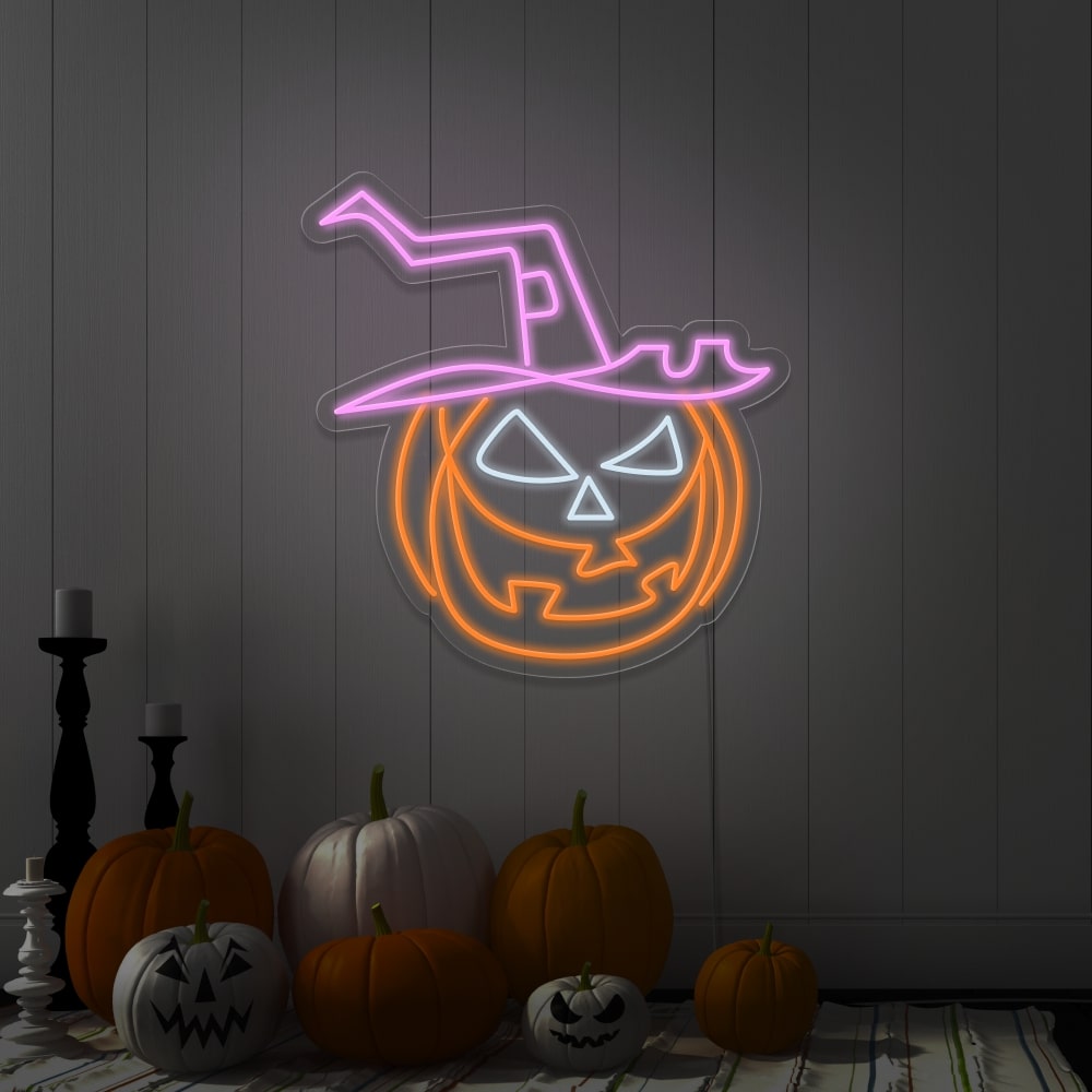 light pink pumpkin hat neon sign hanging on wall next to pumpkins