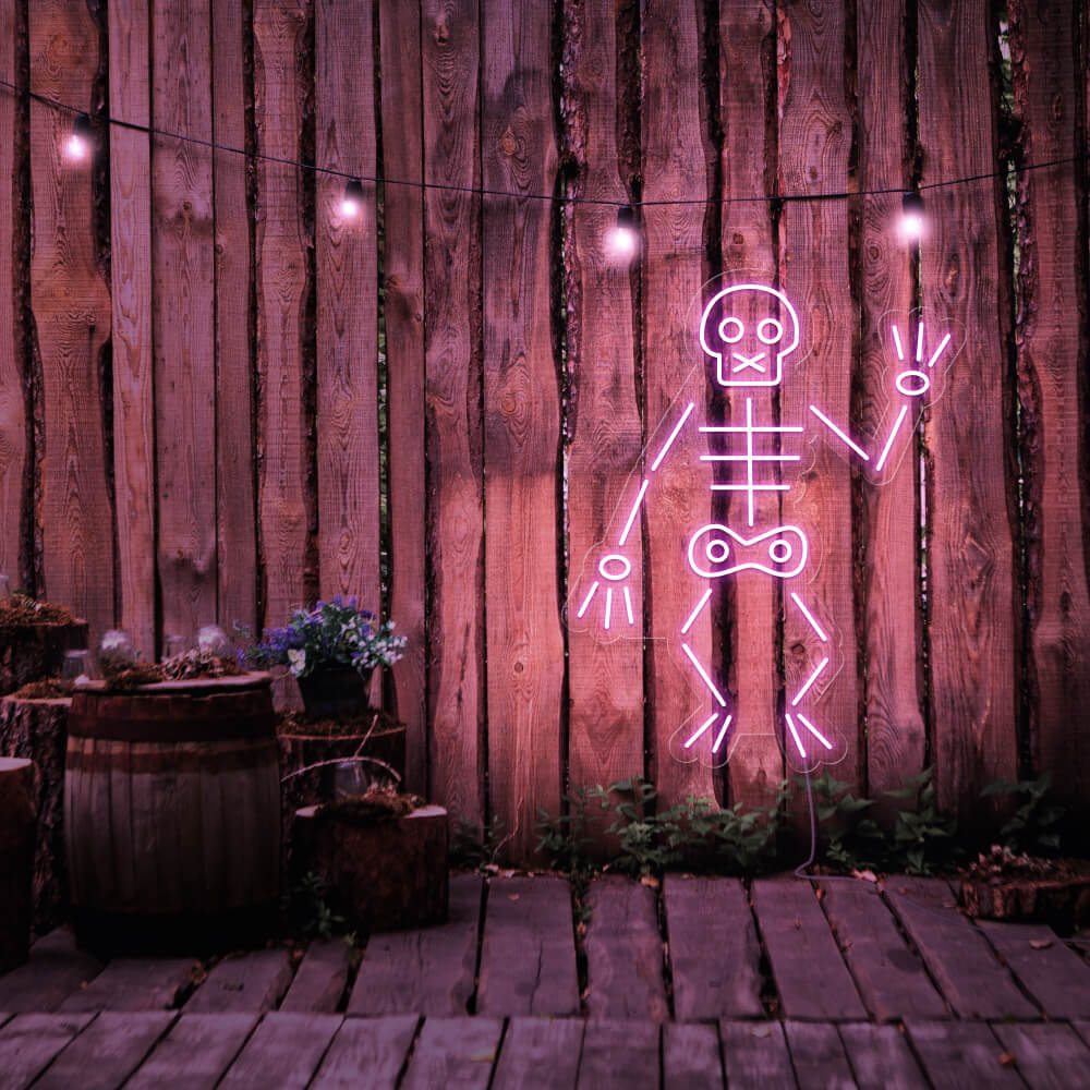 light pink skeleton neon sign hanging on timber fence