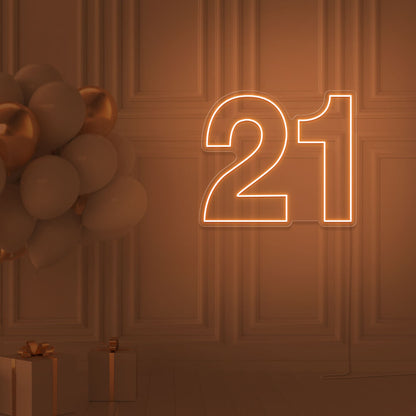 orange  21 neon sign hanging on wall with balloons