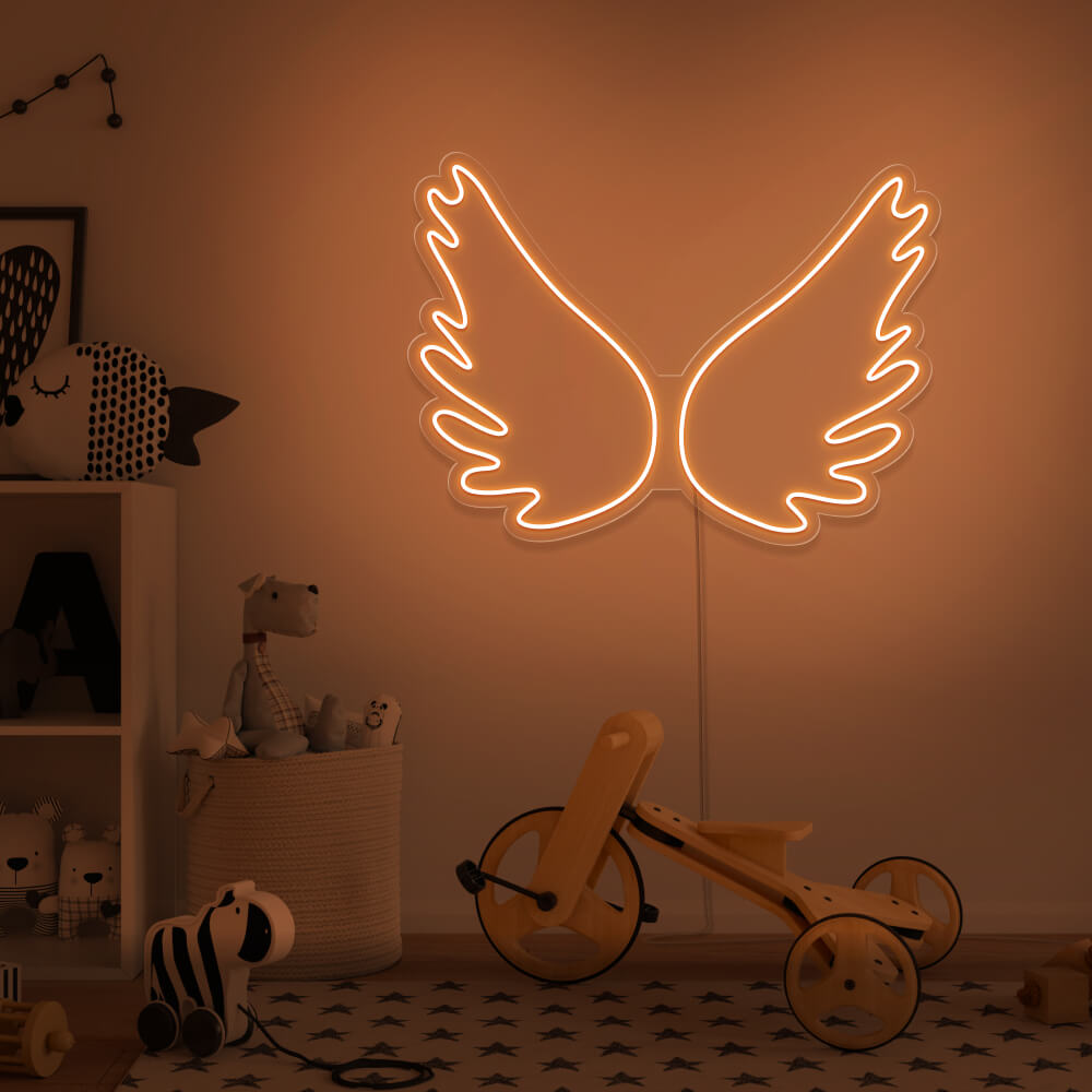 orange angel wings neon sign hanging on kids bedroom wall