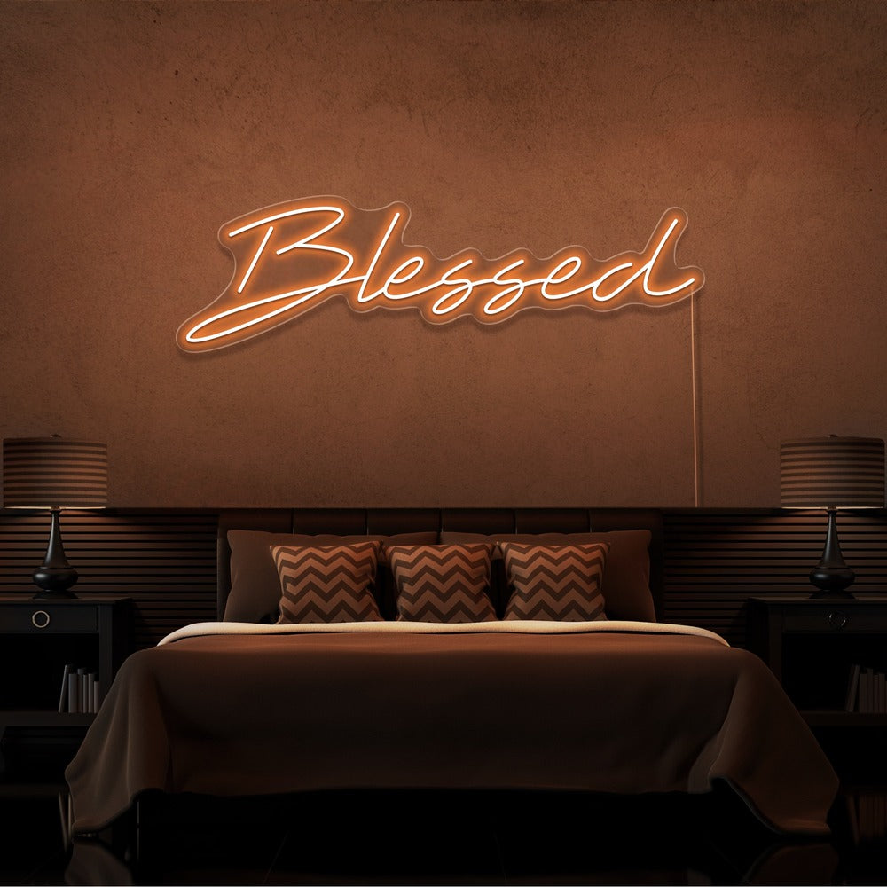 orange blessed neon sign hanging on bedroom wall