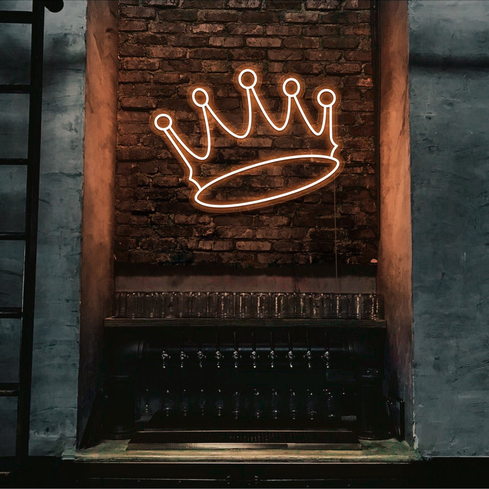 orange crown neon sign hanging on bar wall