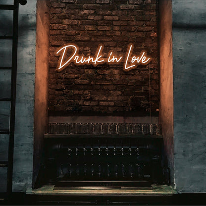 orange drunk in love neon sign hanging on bar wall