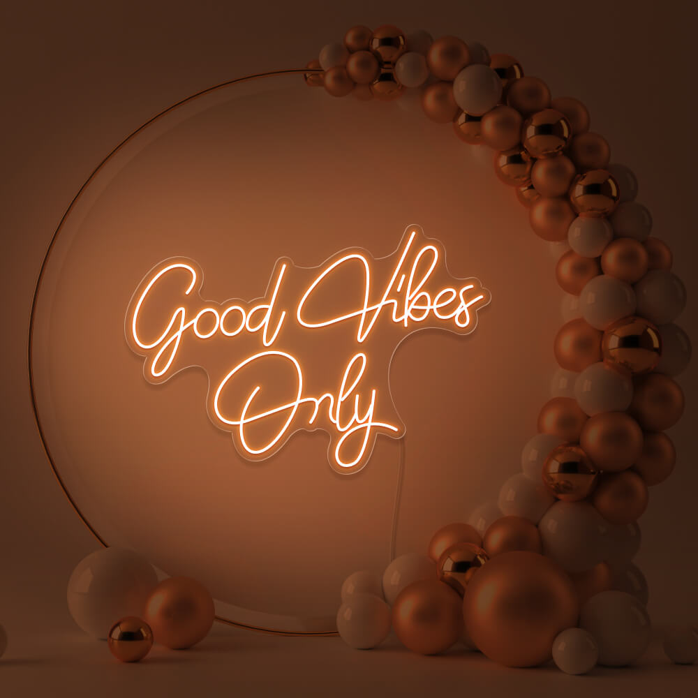 orange good vibes only neon sign hanging inside balloon hoop backdrop