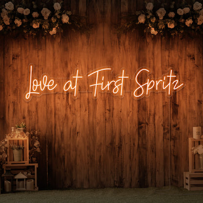 orange love at first spritz neon sign hanging on timber wall