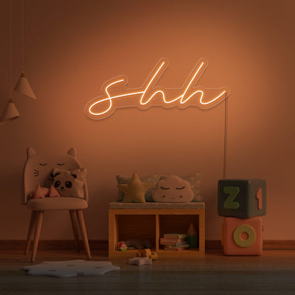 orange shh neon sign hanging on kids bedroom wall