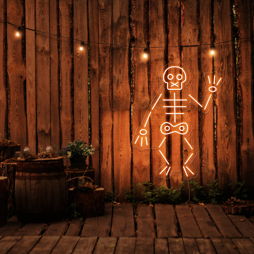 orange skeleton neon sign hanging on timber fence