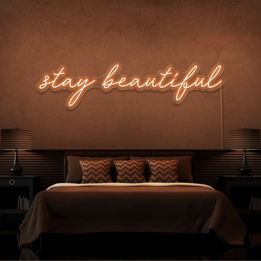 orange stay beautiful neon sign hanging on bedroom wall