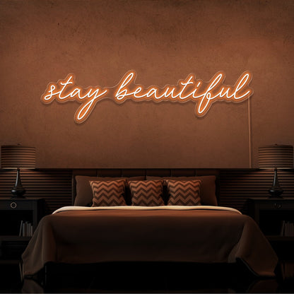 orange stay beautiful neon sign hanging on bedroom wall