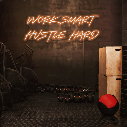 orange work smart hustle hard neon sign hanging on gym wall