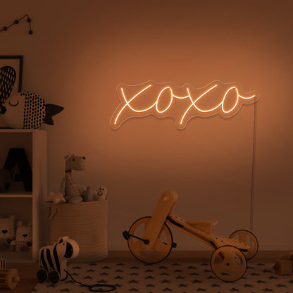 orange xoxo neon sign hanging on kids bedroom wall