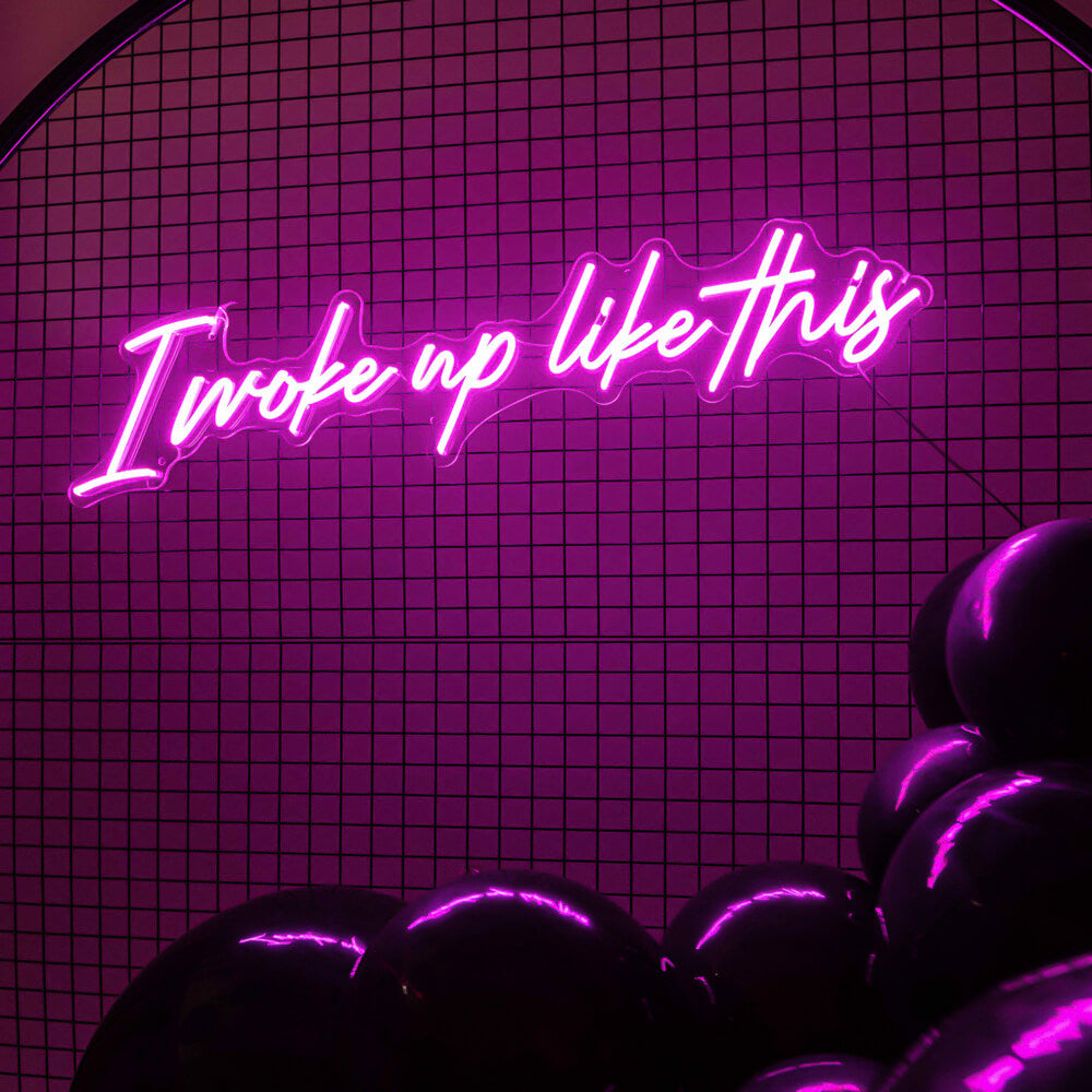 hot pink I woke up like this neon sign hire hanging on black mesh backdrop frame