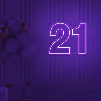 purple  21 neon sign hanging on wall with balloons