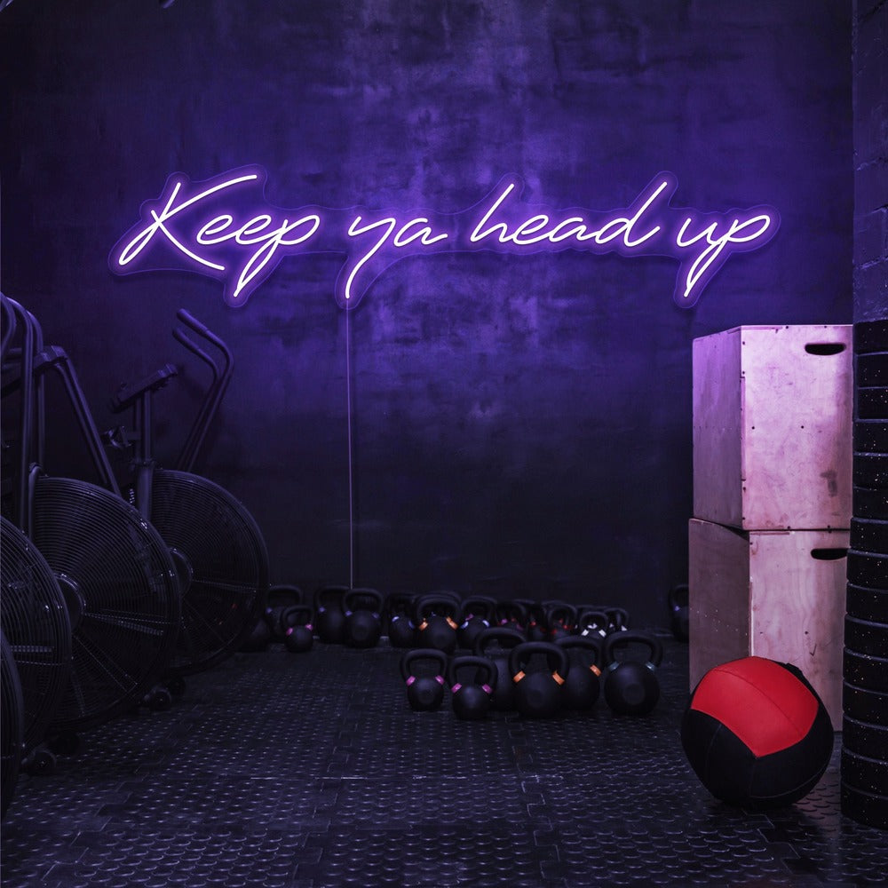 purple keep ya head up neon sign hanging on gym wall