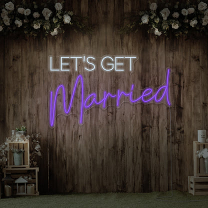 purple lets get married neon sign hanging on timber wall