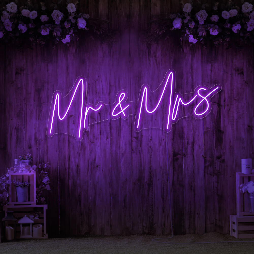 purple mr and mrs neon sign hanging on wall with flowers