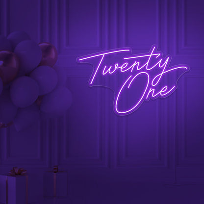 purple  twenty one neon sign hanging on wall with balloons
